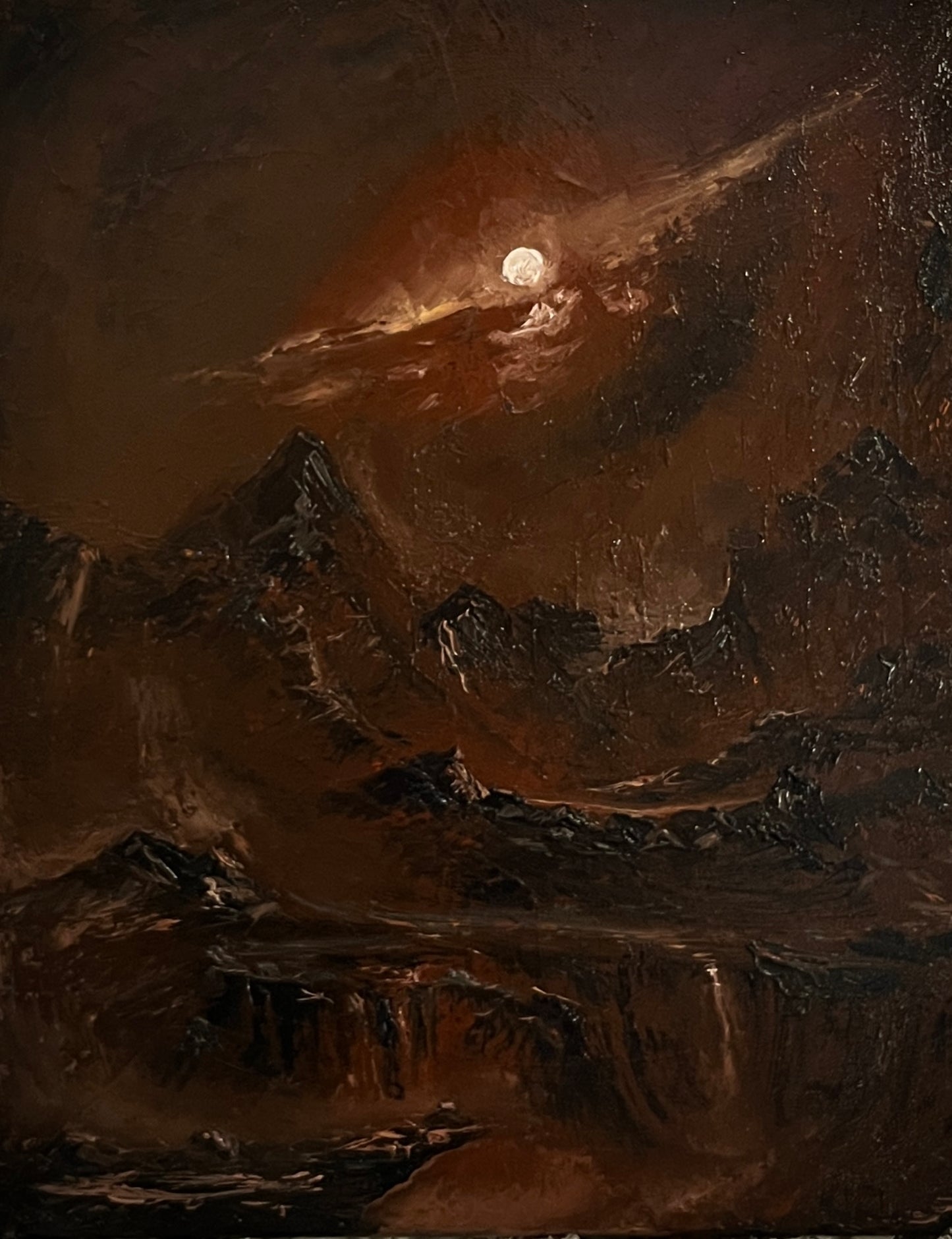 A dark, moody landscape painting depicting rugged mountains under a night sky with a glowing full moon and dramatic clouds.