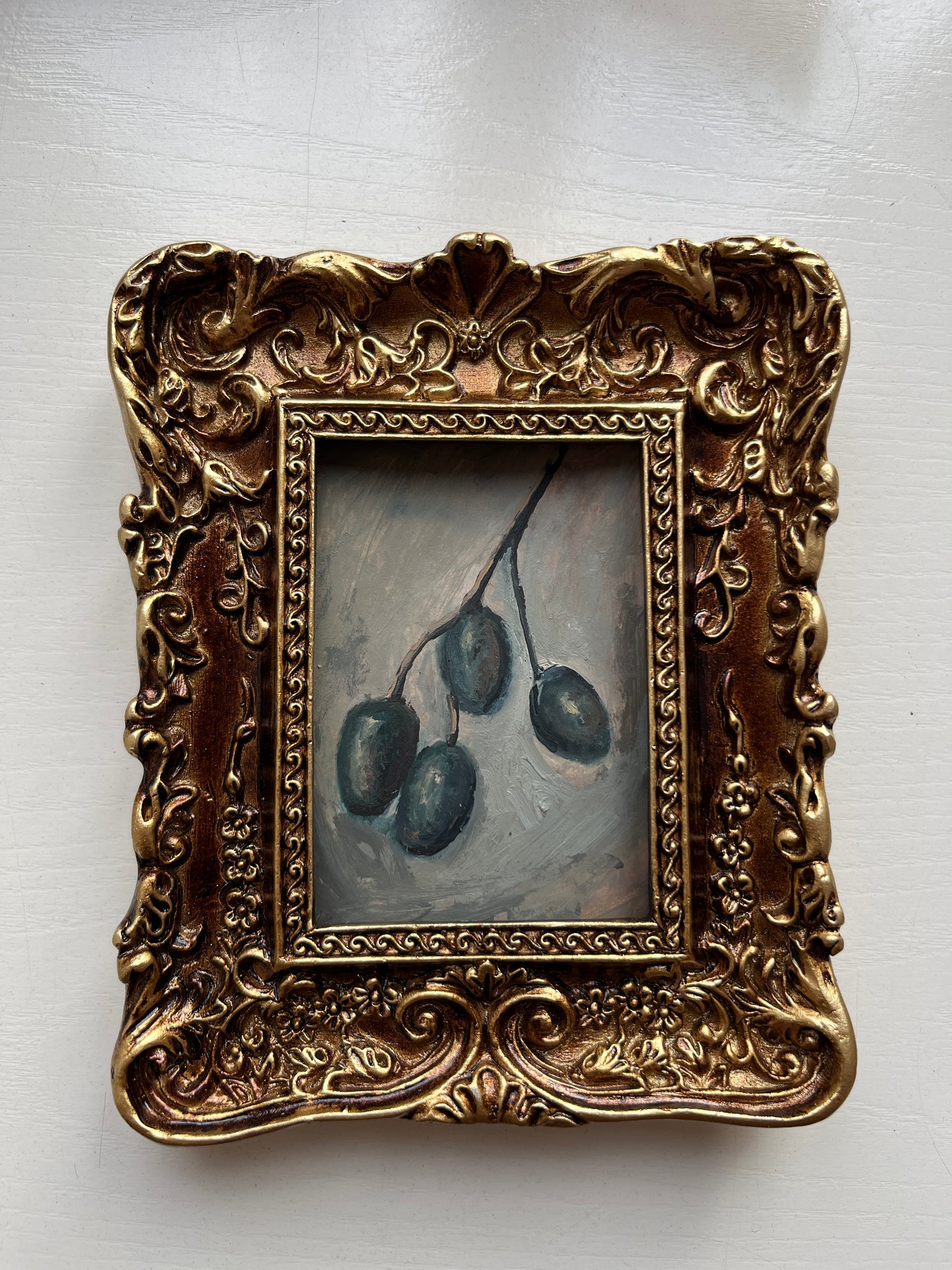 Close-up of realistic oil paint texture and chiaroscuro lighting on the original olive miniature