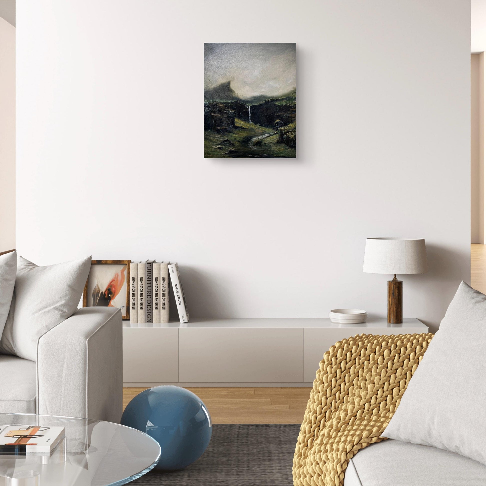 Misty Scottish Highlands landscape oil painting displayed on a wall in a moody living room interior.